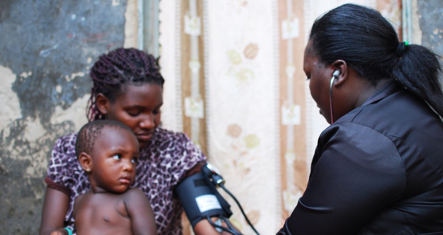 community health worker in uganda treating a mother and daughter