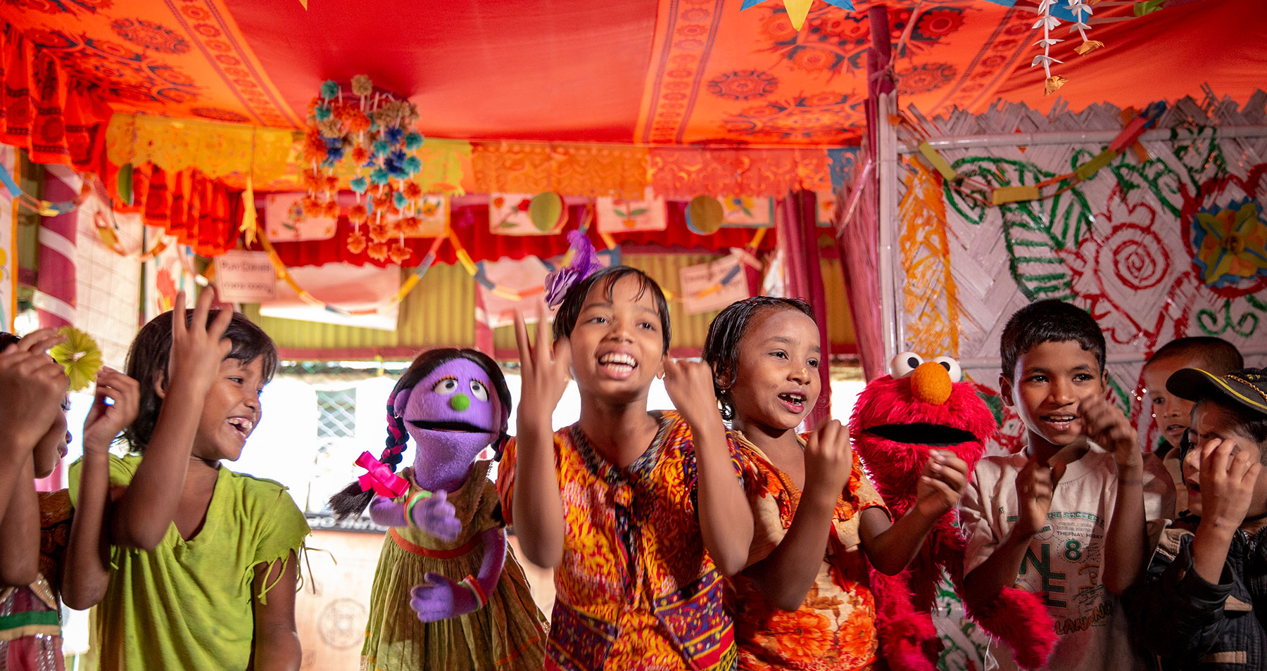 Rohingya children play with muppets in a BRAC Humanitarian Play Lab. Photo by Ryan Donnell for Sesame Workshop.