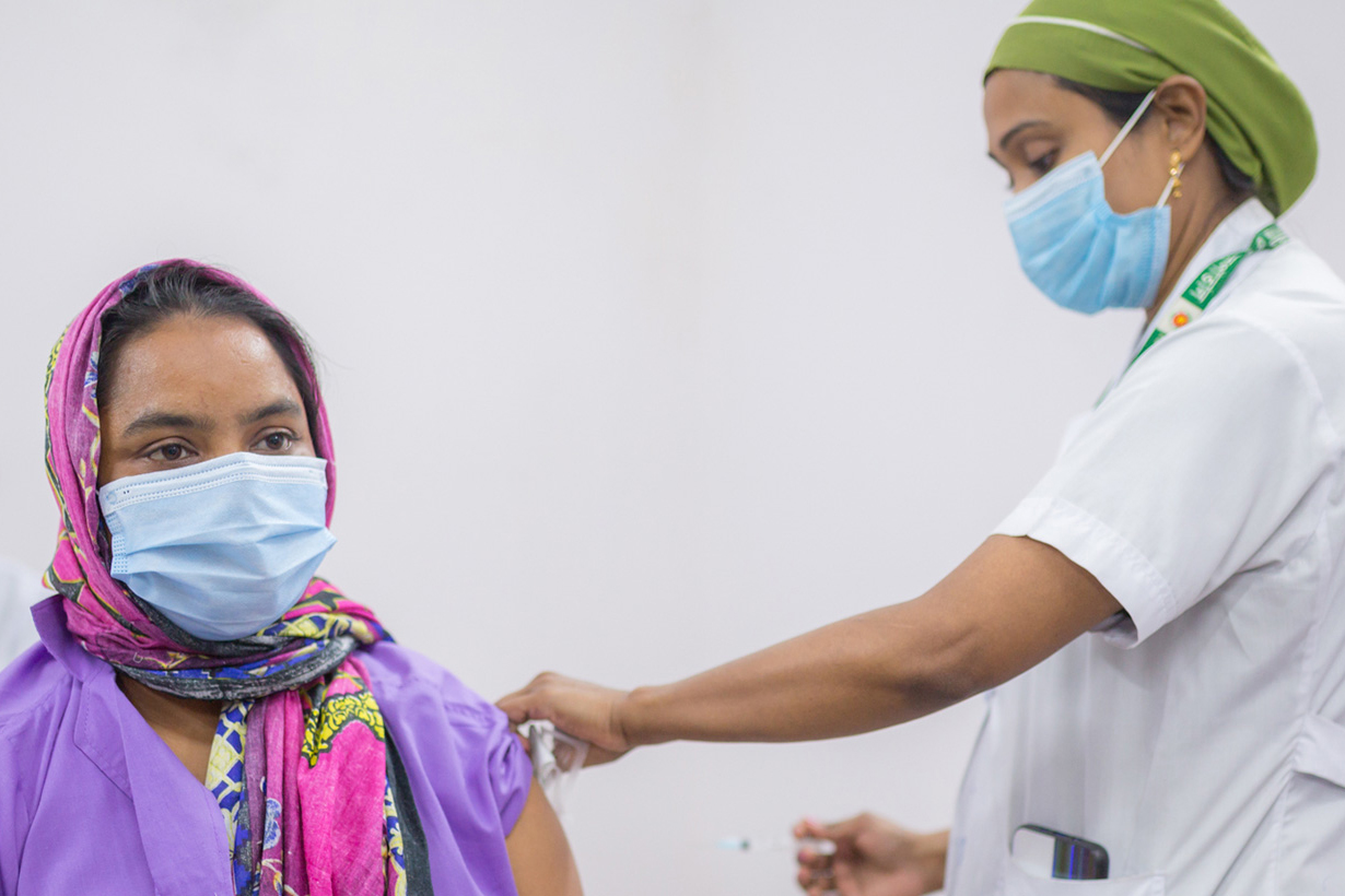 A BRAC community health worker recieves her COVID-19 vaccine