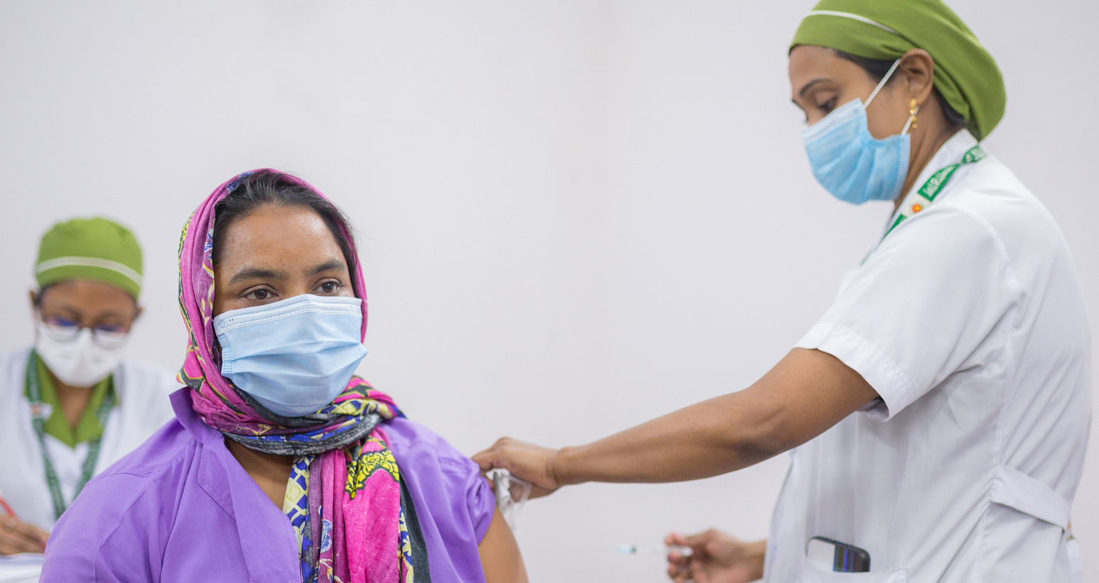 A BRAC community health worker recieves her COVID-19 vaccine