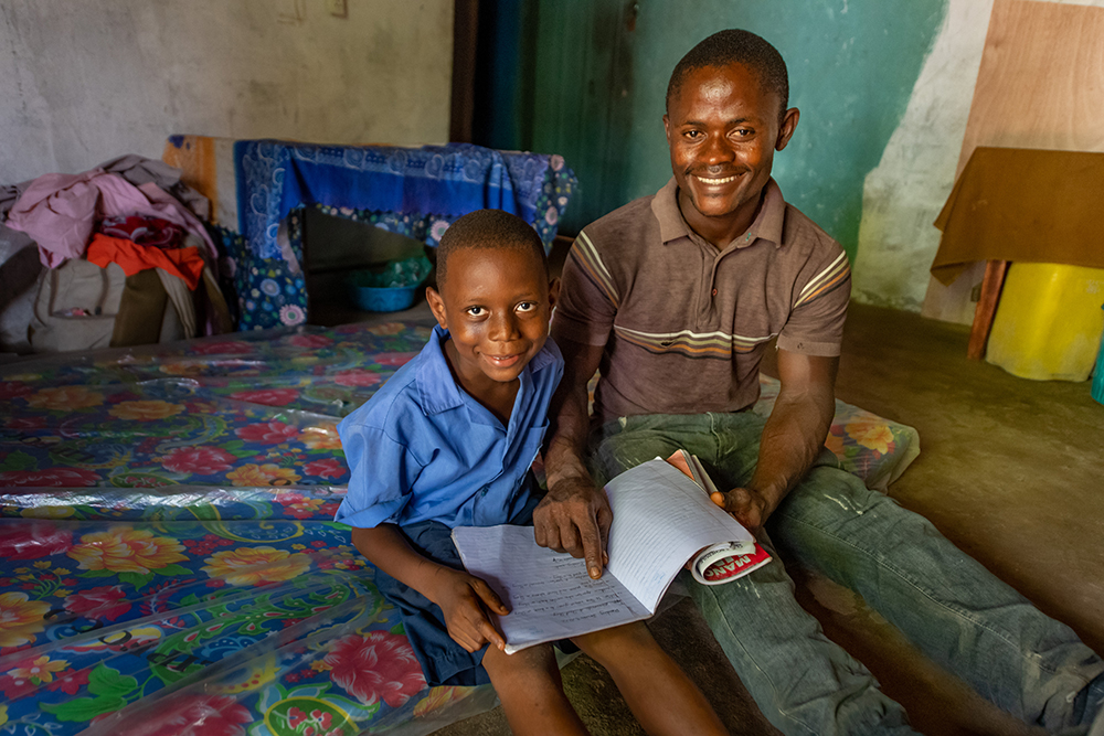 Photo by Alison Wright. Matthew poses with his son while they read together.