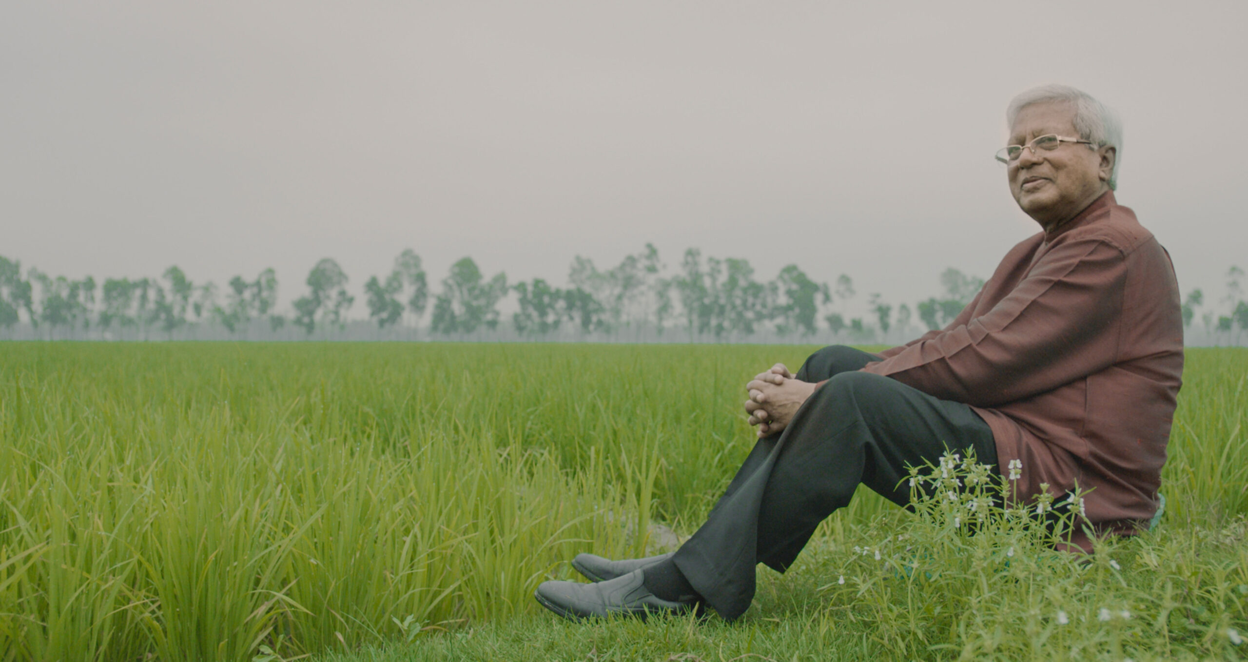 BRAC Founder Sir Fazle Hasan Abed poses next to rice paddies in Bangladesh