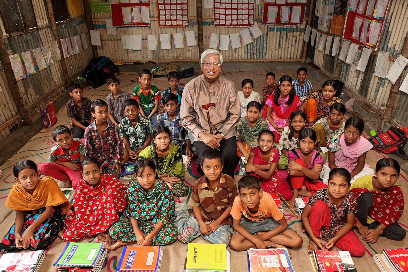 Sir Fazle Hasan Abed sits among a class of students at a BRAC school in Bangaldesh