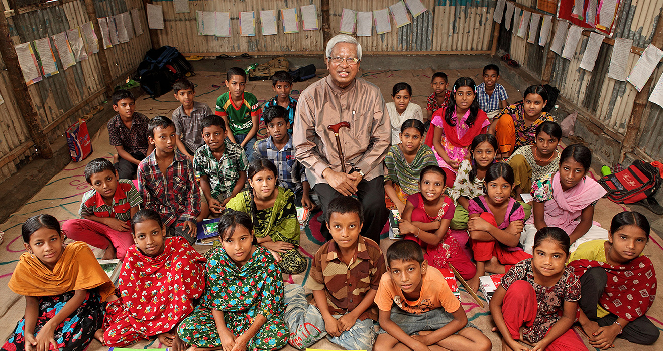 Sir Fazle Hasan Abed sits among a class of students at a BRAC school in Bangaldesh