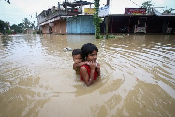 Children in Bangladesh swim through flood waters