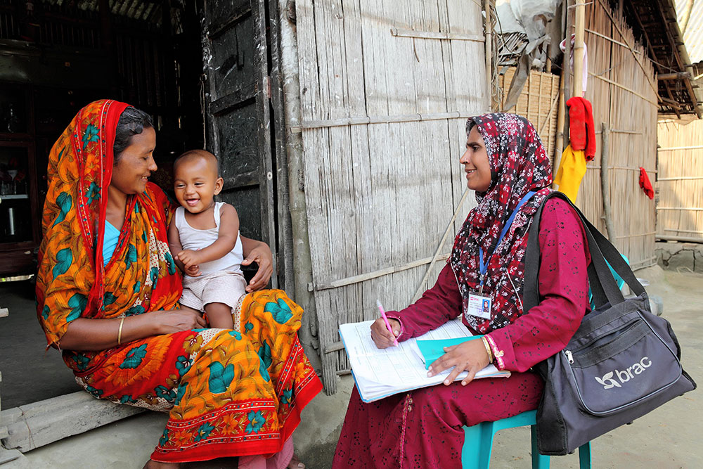 A community health worker consults a mother and her baby in Bangladesh
