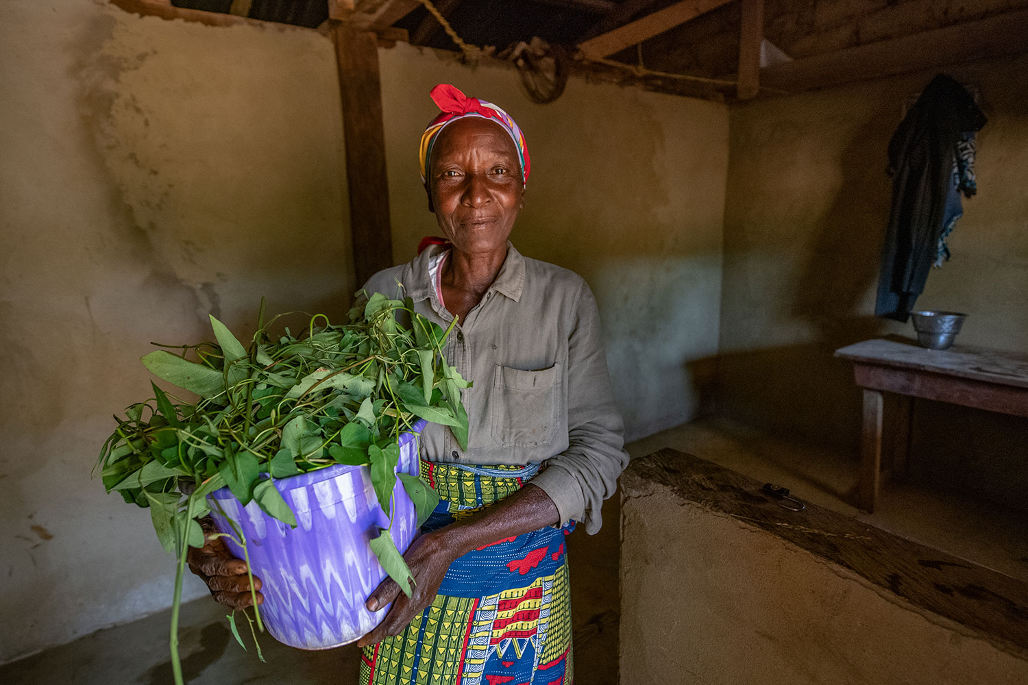 Lucy holds a bundle of produce from her kitchen garden while in her home