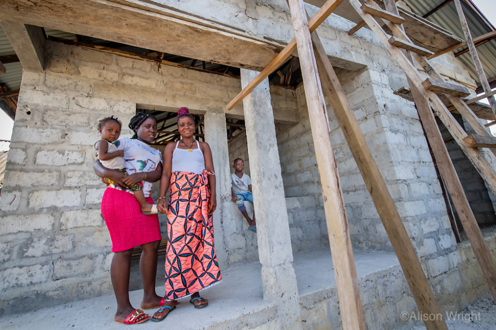 Jebbeh and her family pose in front of their new home which is under construction. Photo by Alison Wright.
