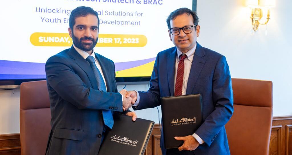 Representatives from BRAC and Silatech shake hands at a signing ceremony launching the partnership.