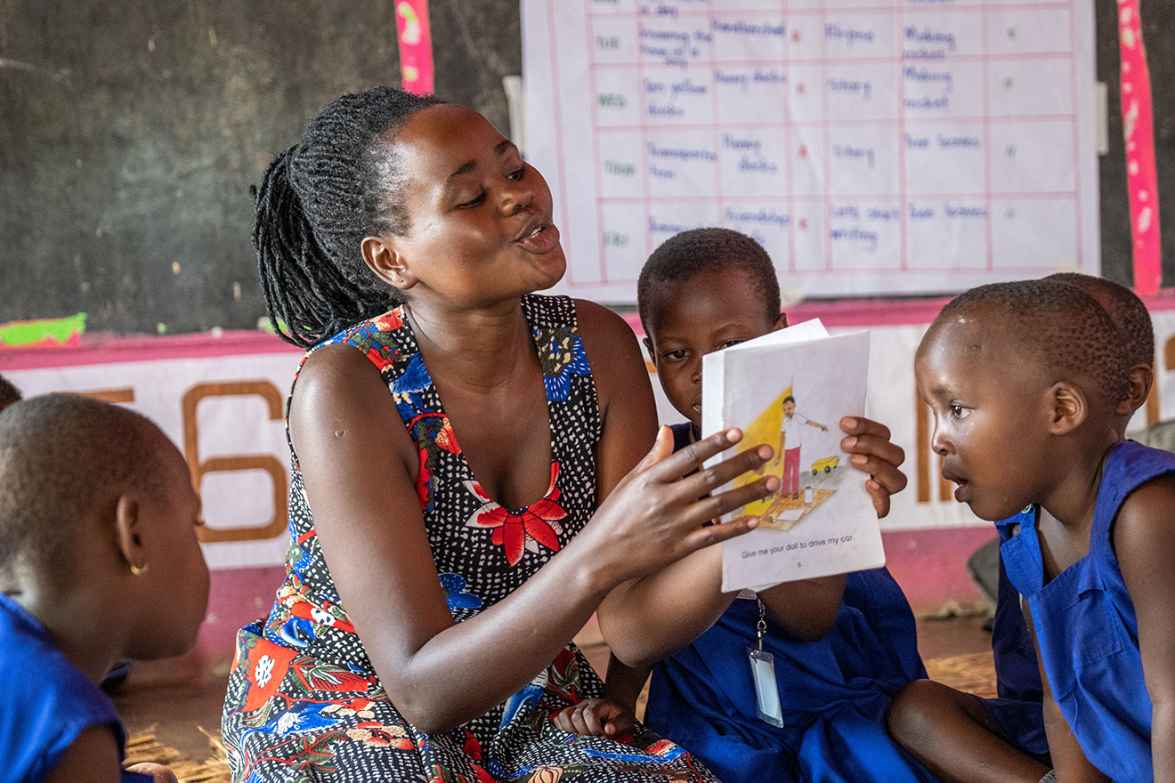 An animated Play Leader reads to a group of children in a Play Lab in Uganda. Photo by Lee Cohen/Local Story.