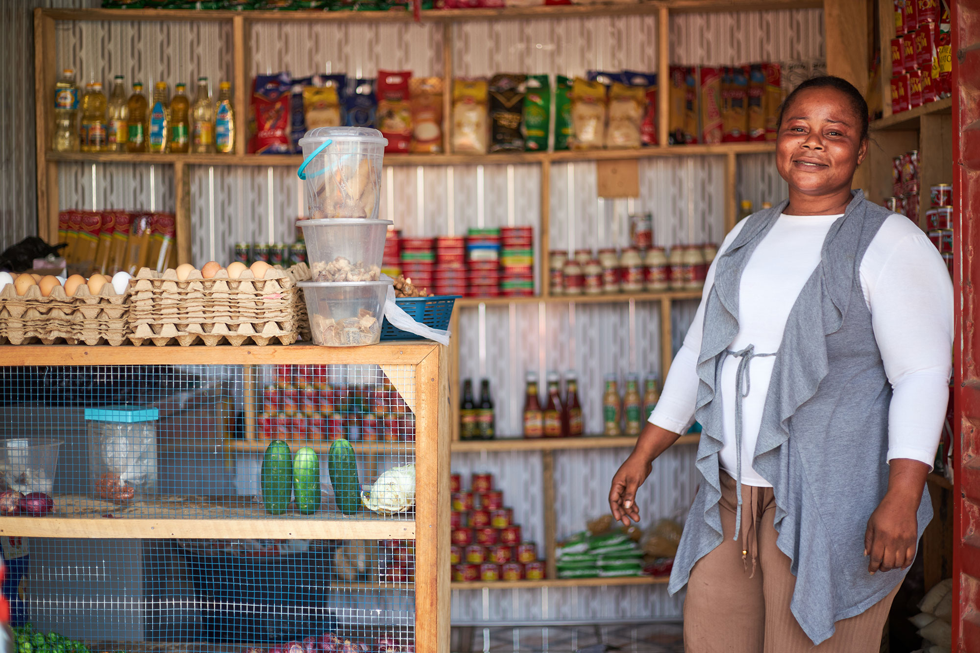 Sophia, a microfinance borrower in Ghana, stands in her shop.
