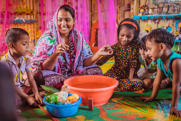 A Play Leader facilitates a sensory play activity with a small group of children in a BRAC Play Lab.