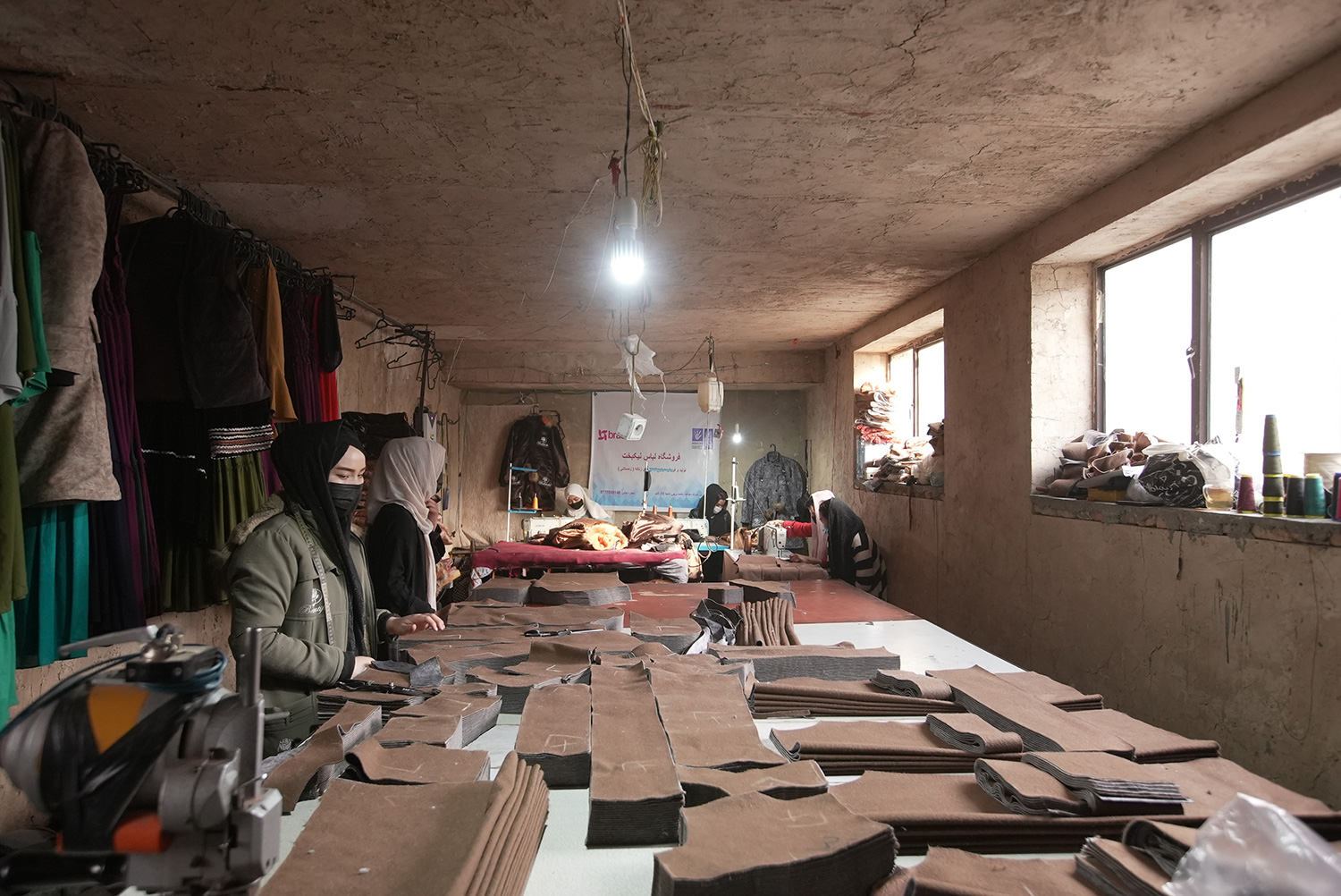 Tailoring apprentices in Afghanistan cut and sort material to make coats.