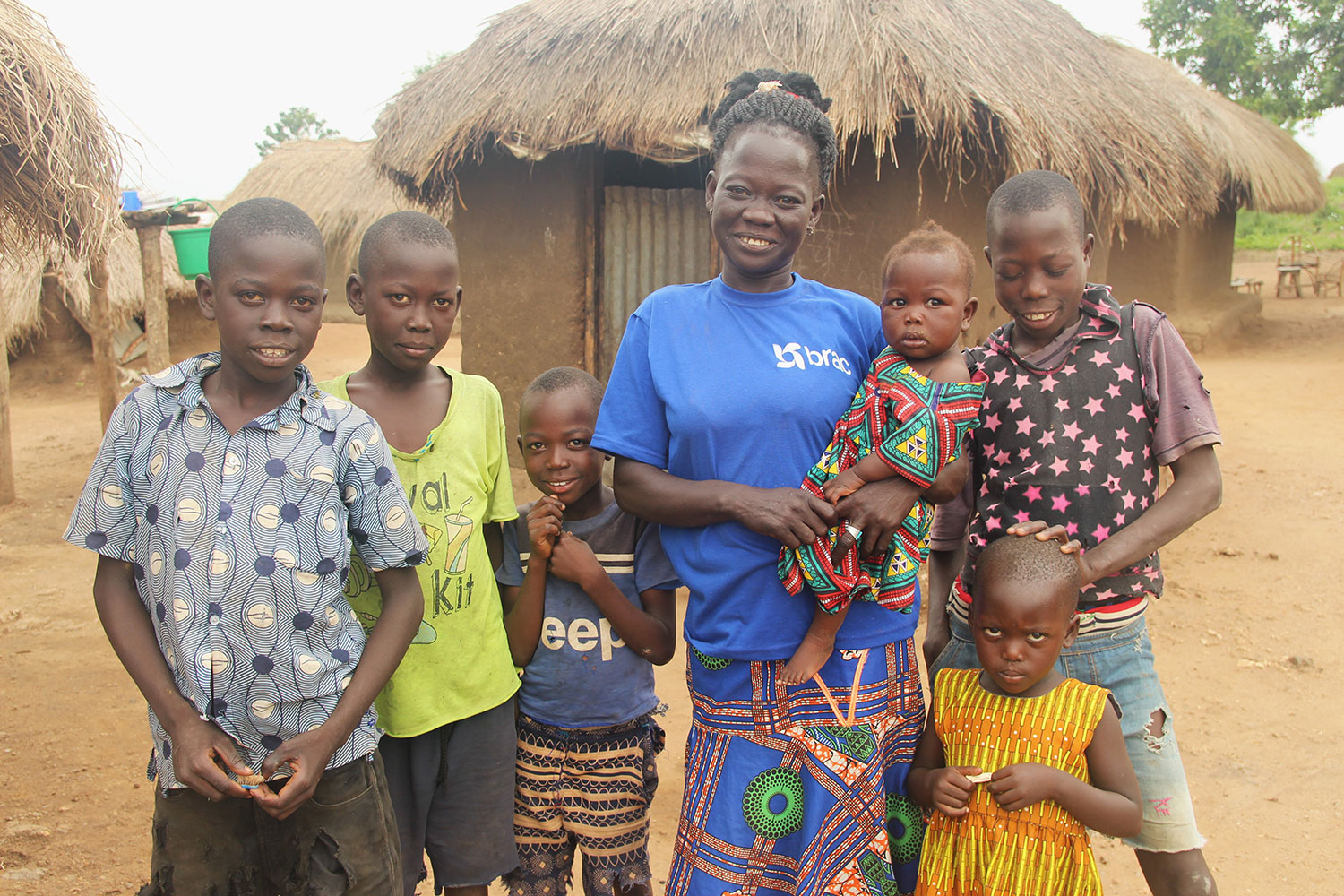 Edina, a South Sudanese refugee living in Uganda, poses with her family