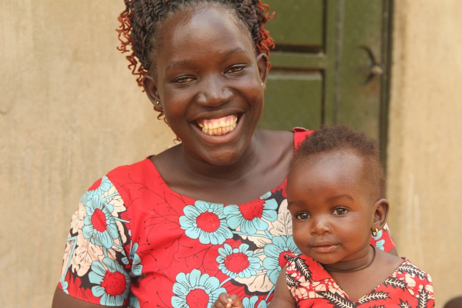 Lonah holds her daughter and smiles.