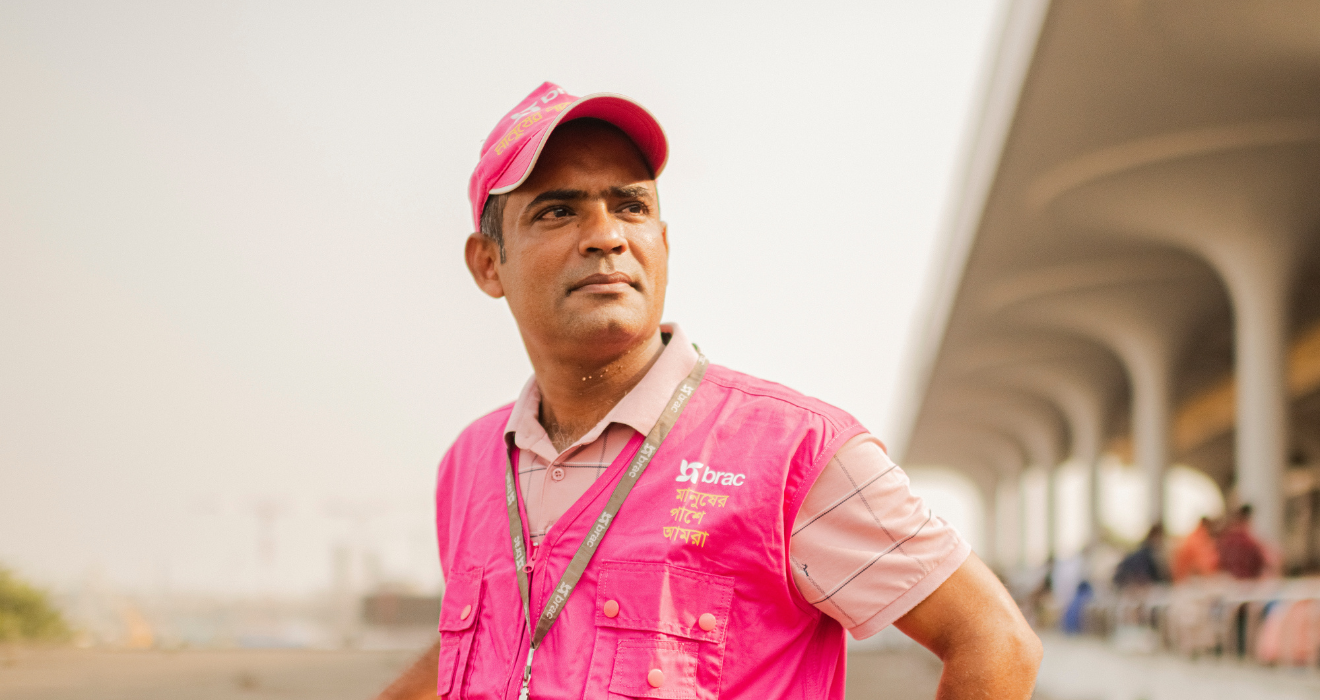 Al-Amin Noyon stands in front of Dhaka's airport, where he supports migrant workers and fights trafficking.