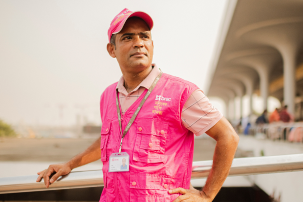 Al-Amin Noyon stands in front of Dhaka's airport, where he supports migrant workers and fights trafficking.