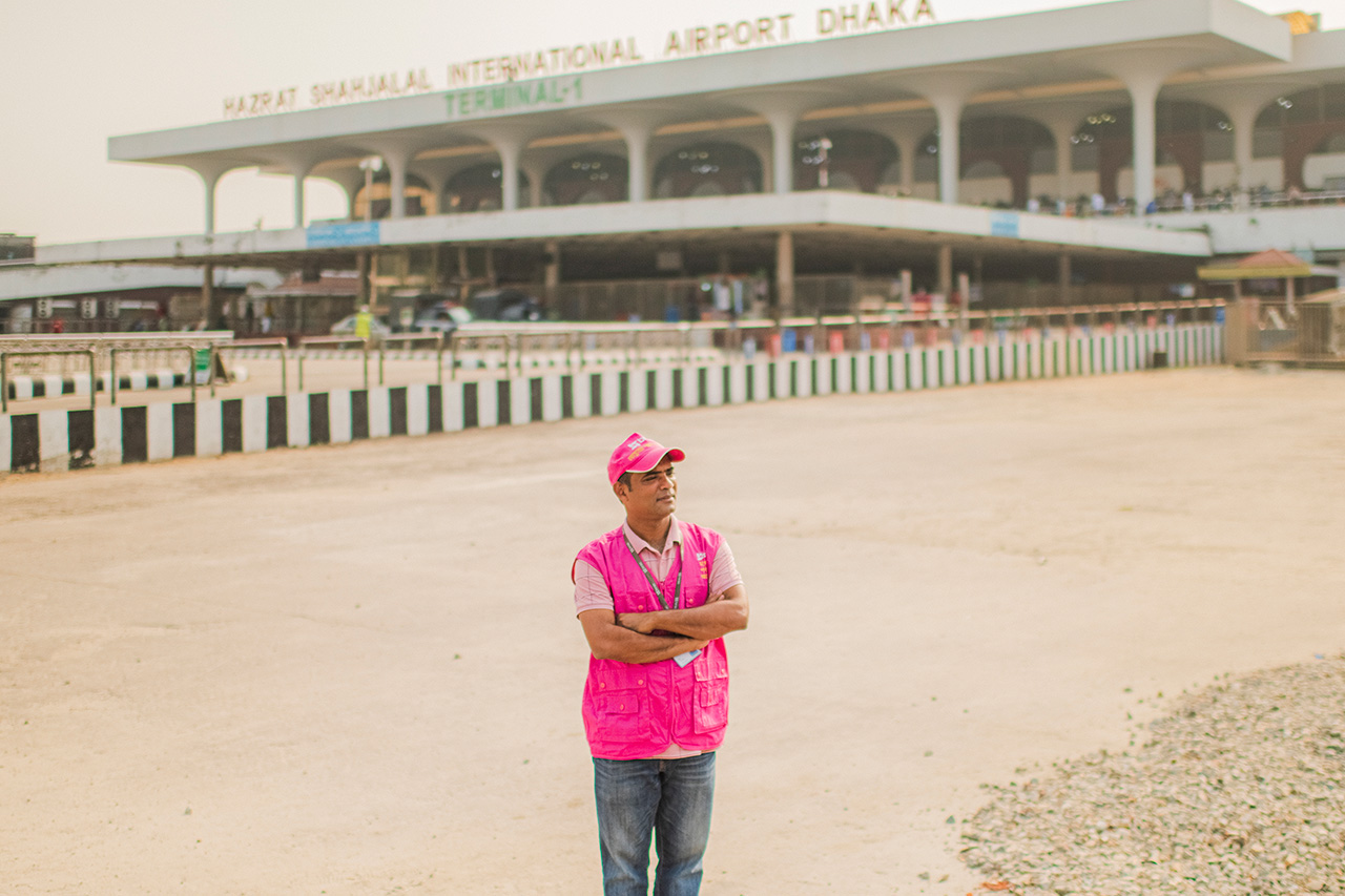 Al-Amin Noyon stands in front of Dhaka's airport, where he supports migrant workers and fights trafficking.