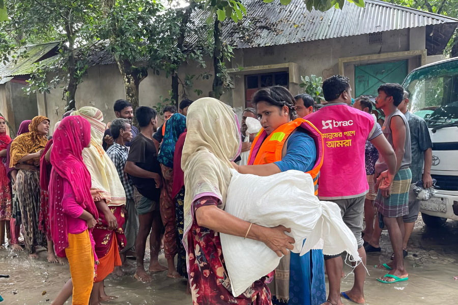 August 25, 2024: Rima Akter, a BRAC staff member, delivers a dry food kit to a flood victim in Nangalkot, Comilla. In addition to delivering aid, to keep communities informed, frontline staff like Rima share life-saving awareness messages, and BRAC has also broadcast these messages to the wider public through three community radio stations.