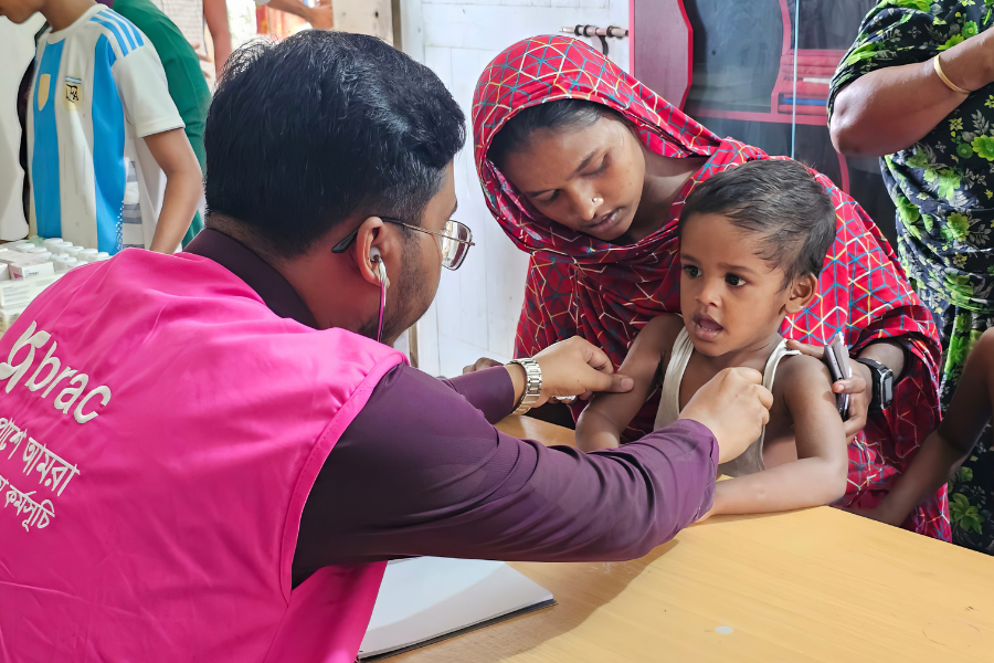 August 27, 2024: A health worker sees a young patient affected by the flooding. BRAC has deployed seven medical teams, including seven medical officers and 21 paramedics. Working across five severely affected districts, these teams are providing urgent health care services, delivering care for people with injuries and infections — with a particular focus on caring for children who fall ill from exposure to the flood.