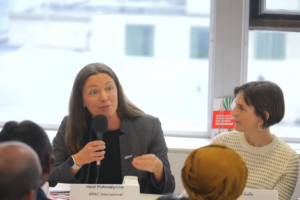 Heidi McAnnally Linz of BRAC speaks into a microphone while sitting at the panelist table at a UN week side event.