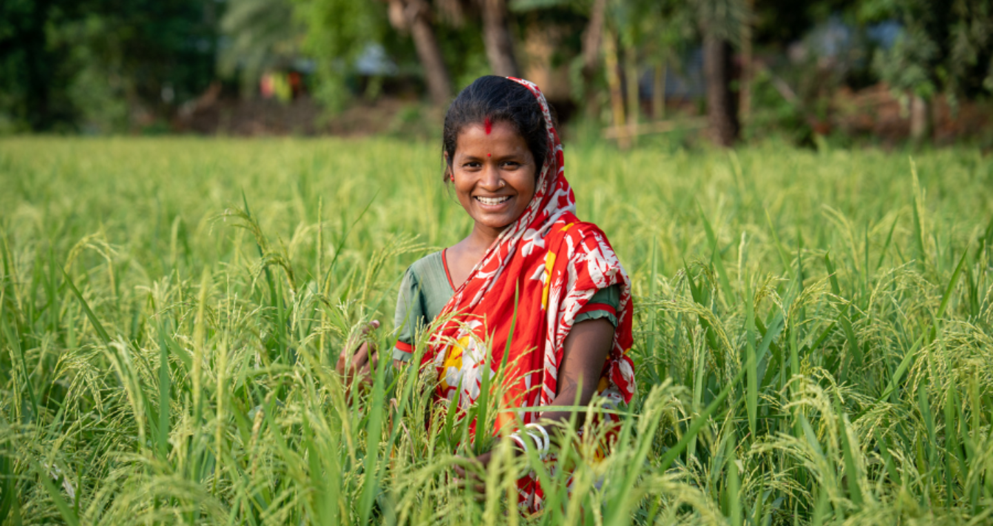 A participant in BRAC's Ultra-Poor Graduation program in Bangladesh poses in her rice field.