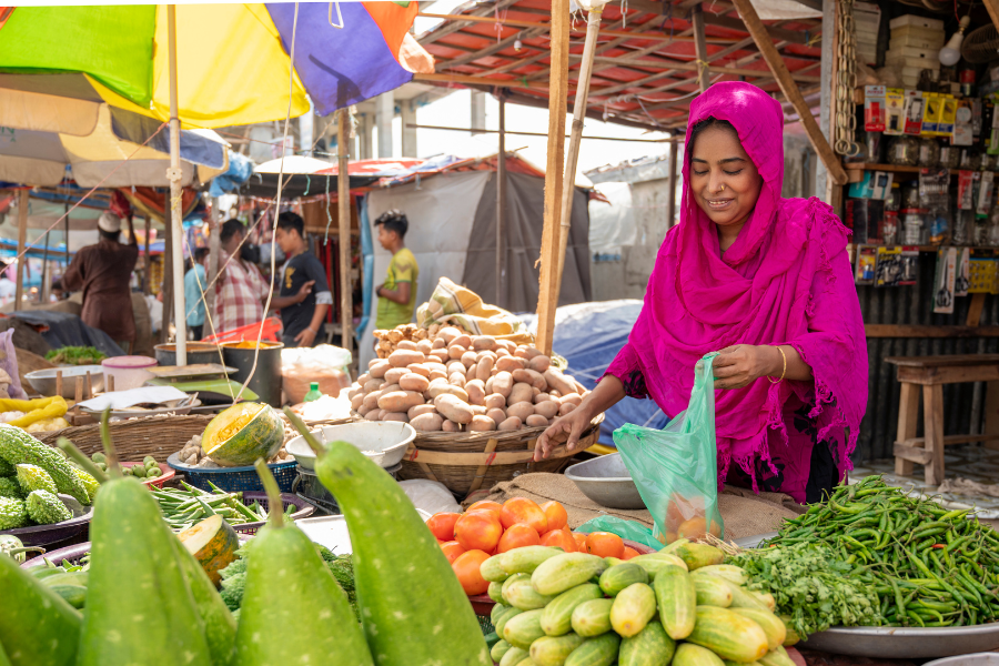 Shahinur bags produce at her produce shop.