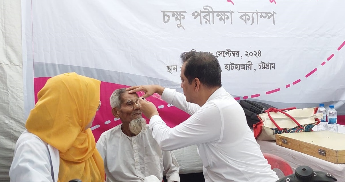 A BRAC medical personnel treats a child who sits on his mother's lap.