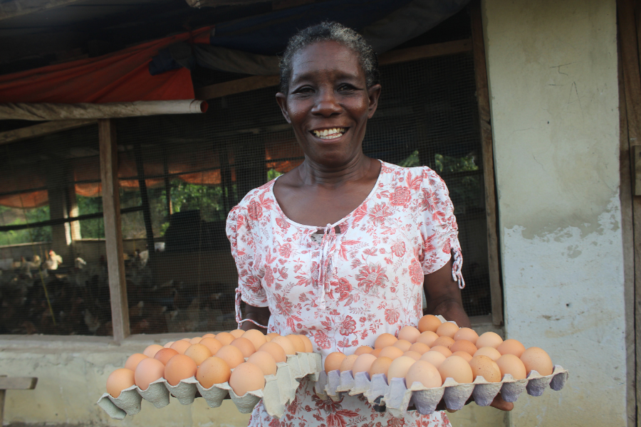 Selena holds two cartons of eggs and smiles.