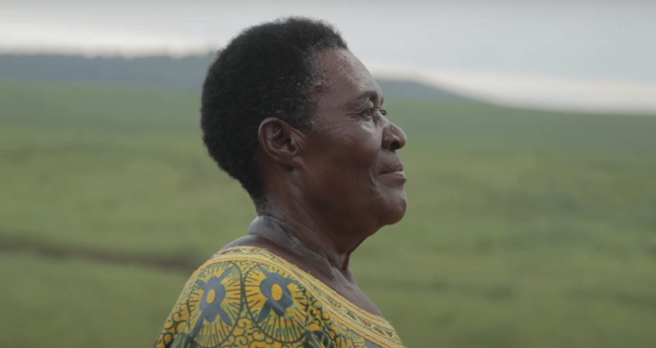 Mary stands in front of a hillside overlooking her community