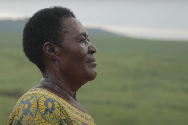 Mary stands in front of a hillside overlooking her community