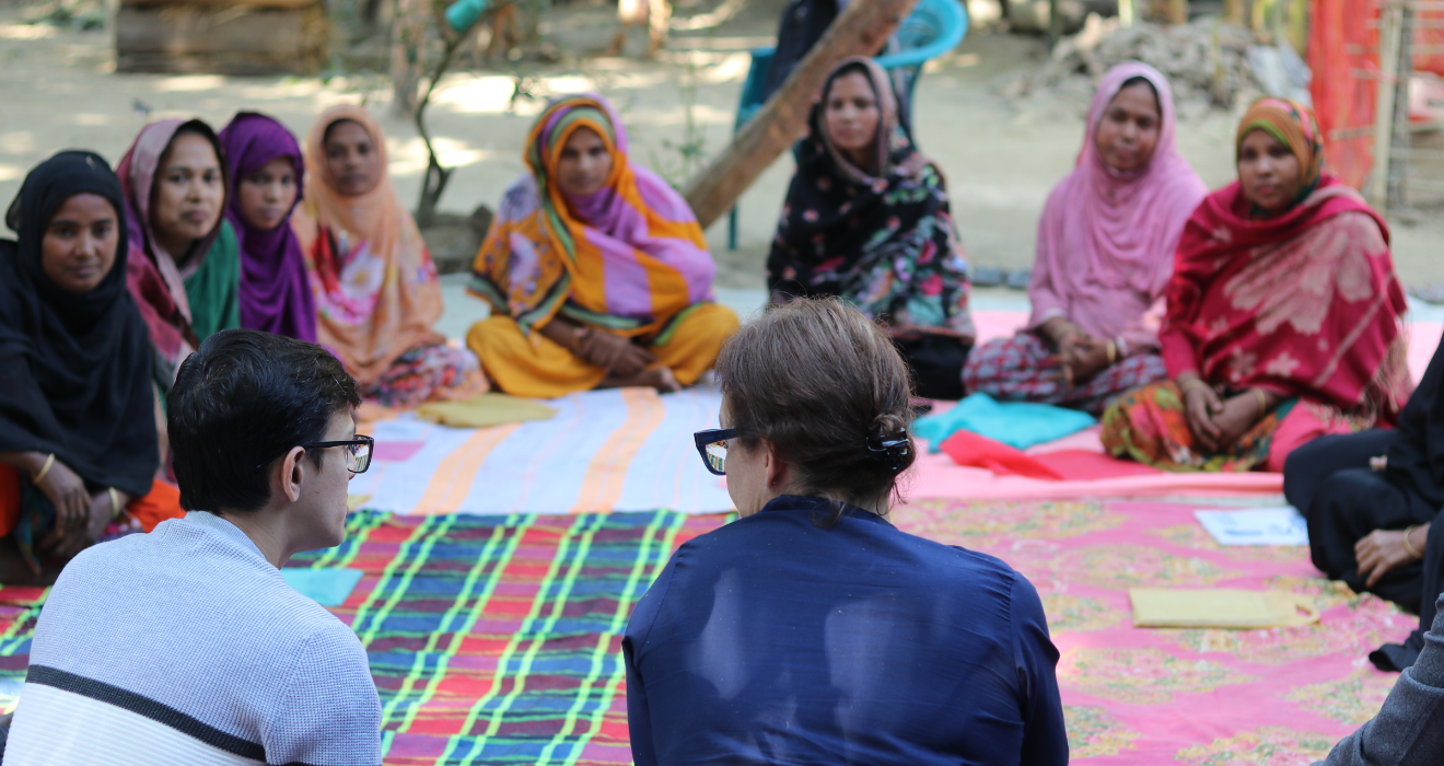 Julia Roberts, CEO of BRAC USA, sits in a circle with a group of participants and a staff member from an Ultra-Poor Graduation program in Bangladesh.