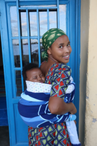 Nadine poses with her baby on her back.