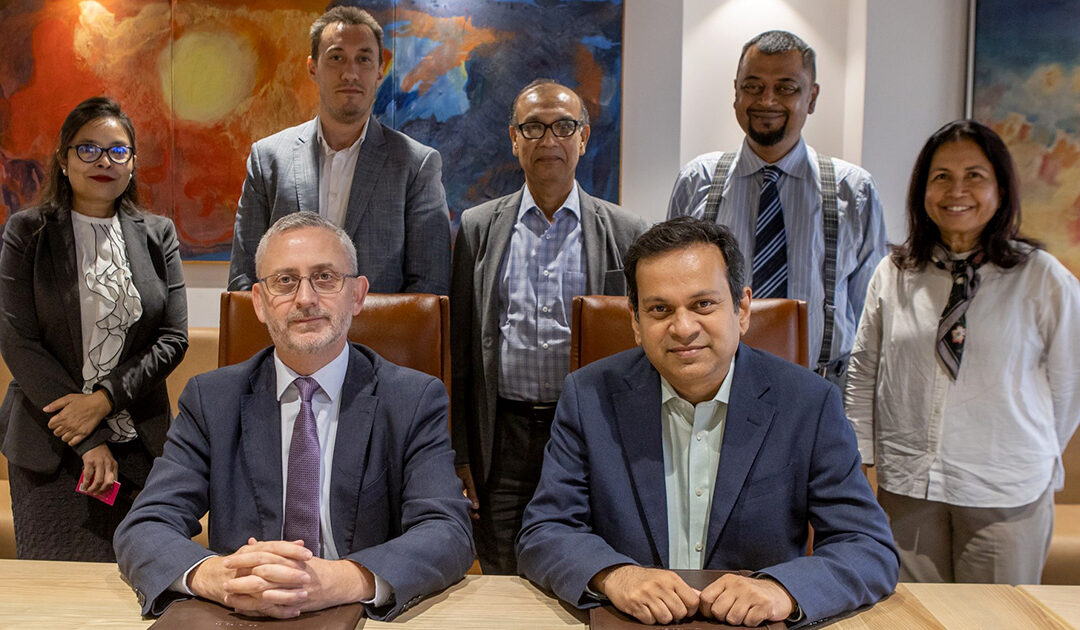 Leaders from BRAC and the European Union pose around a conference table after signing an agreement.