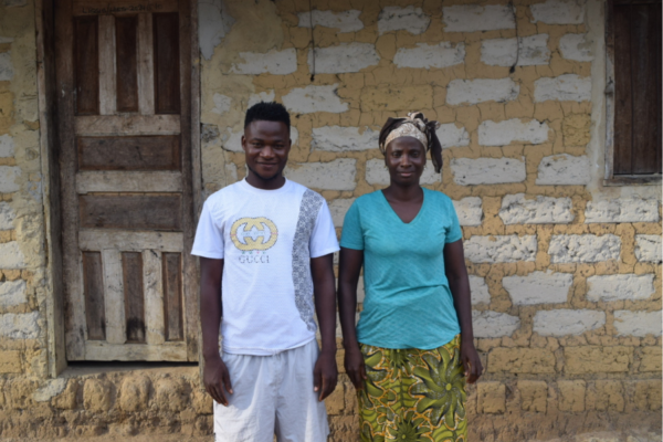 Standing in front of her home, Mamie poses with her son Michelle, who informed me that he has graduated from high school and is looking to start a charcoal business.