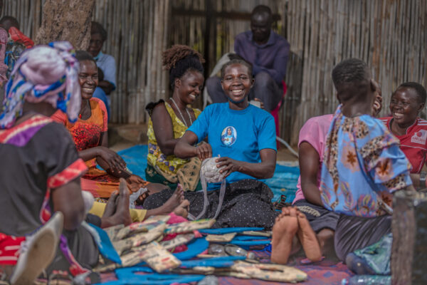 Parents make play materials for their children who attend Play Labs in Rhino Refugee Camp.