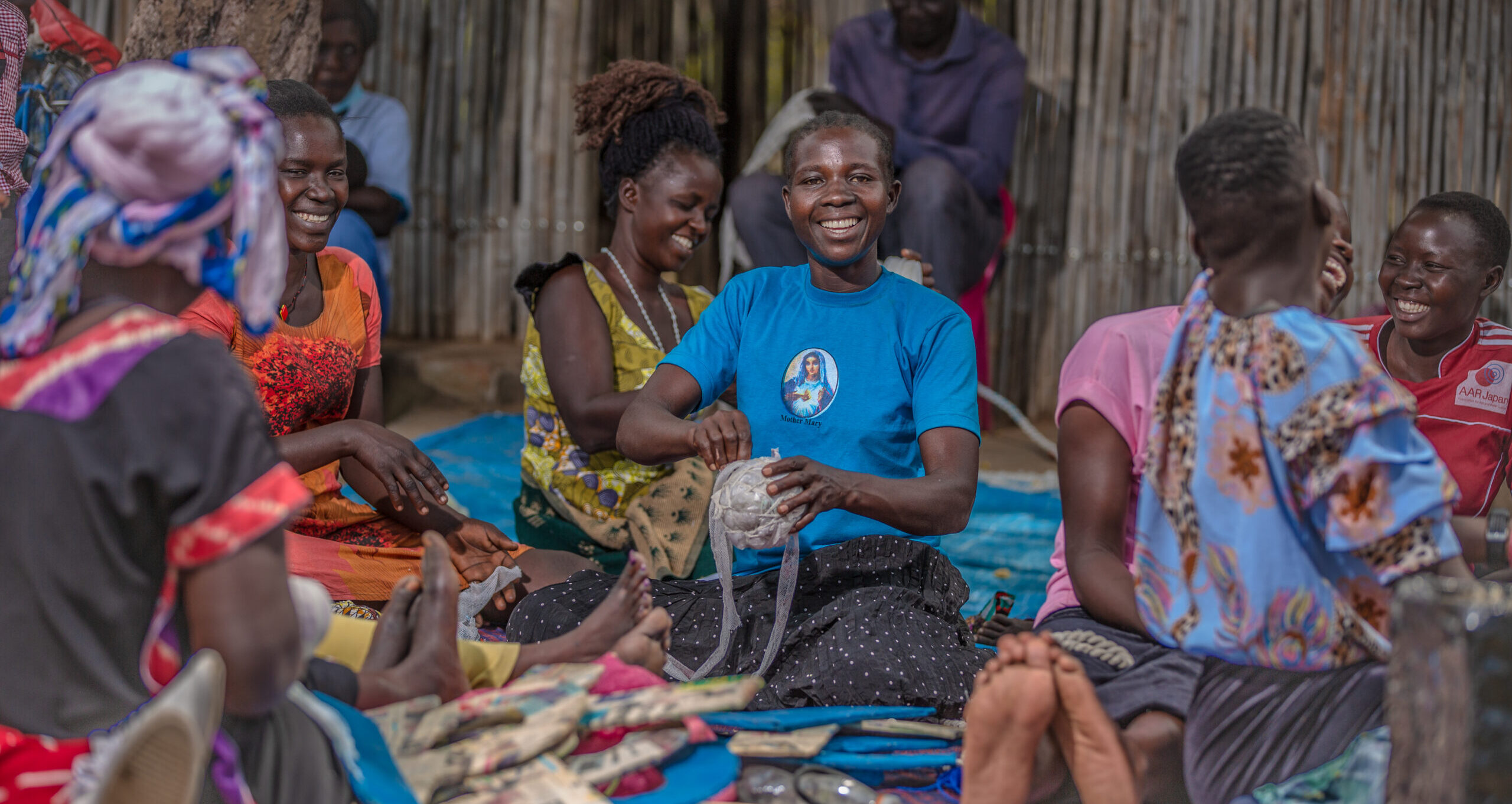 Parents make play materials for their children who attend Play Labs in Rhino Refugee Camp.