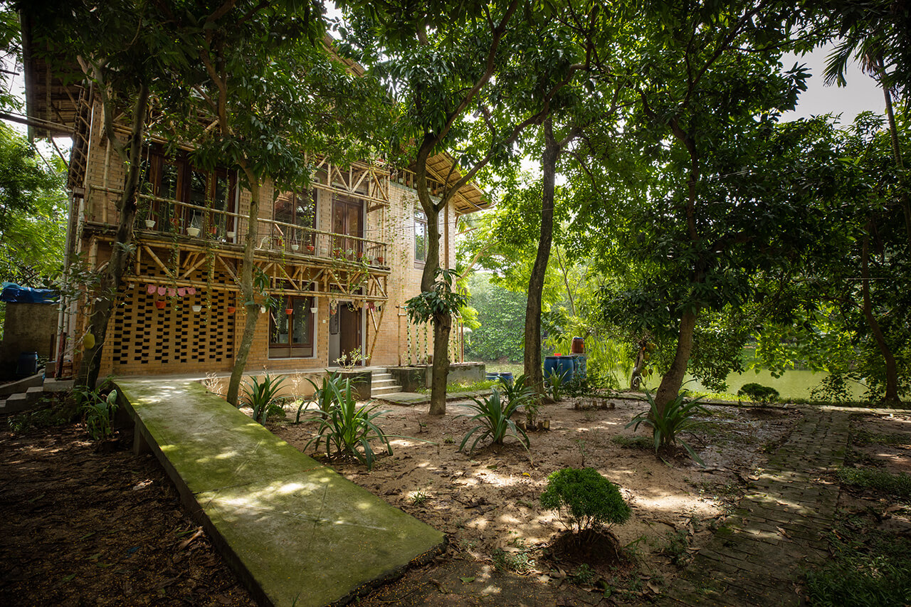 The amphibious house with its front yard that has an aquaponics setup and a ramp for persons with disabilities to access the entrance. © Shamim Hossain, BRAC 2025