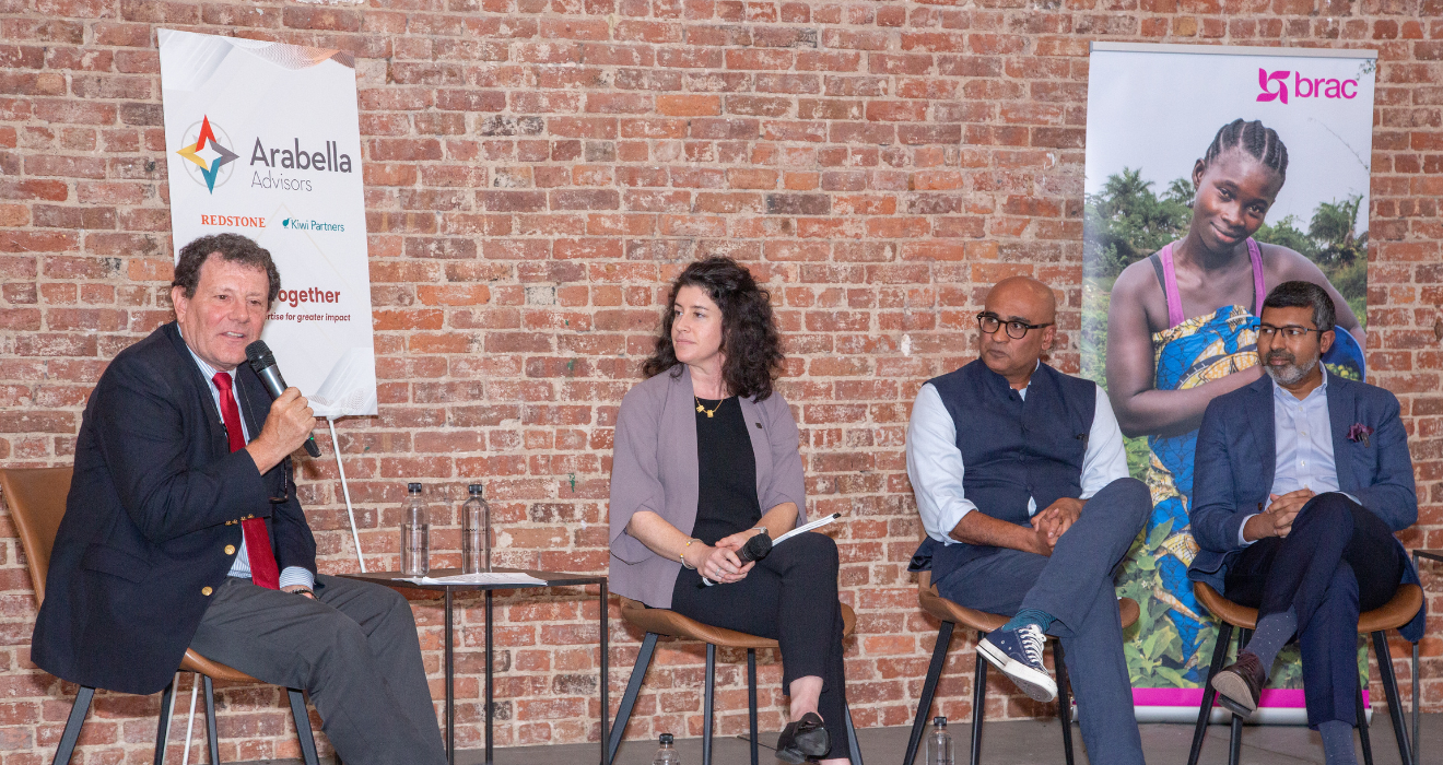 Panelists sit on a small stage in front of a brick wall. From left to right: Nicholas Kristof, a Pulitzer Prize–winning journalist with The New York Times; Alison Fahey, Global Director of Partnerships and Strategic Initiatives at J-PAL; Himesh Bhise, CEO of Arabella Advisors; and Shameran Abed, Executive Director of BRAC International.