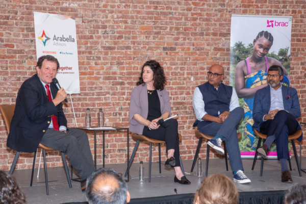 Panelists sit on a small stage in front of a brick wall. From left to right: Nicholas Kristof, a Pulitzer Prize–winning journalist with The New York Times; Alison Fahey, Global Director of Partnerships and Strategic Initiatives at J-PAL; Himesh Bhise, CEO of Arabella Advisors; and Shameran Abed, Executive Director of BRAC International.