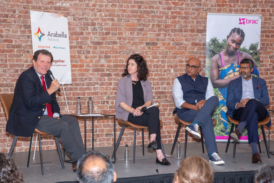 Panelists sit on a small stage in front of a brick wall. From left to right: Nicholas Kristof, a Pulitzer Prize–winning journalist with The New York Times; Alison Fahey, Global Director of Partnerships and Strategic Initiatives at J-PAL; Himesh Bhise, CEO of Arabella Advisors; and Shameran Abed, Executive Director of BRAC International.